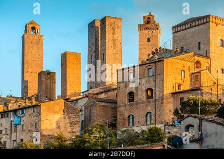 Die mittelalterlichen Türme von San Gimignano, der Toskana, Italien (UNESCO-Weltkulturerbe) dominieren die Skyline der Stadt im Mai bei Sonnenuntergang. Stockfoto