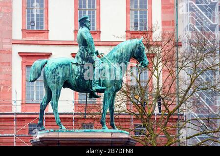 Bronzene Pferdereiter-Statue, die den Ludwig IV., Großfürst von Hessen mit dem Wohnpalast im Hintergrund darstellt. Darmstadt-Land. Stockfoto