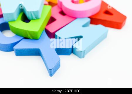 Bunte Buchstaben aus Holzalphabet isoliert auf weißem Hintergrund. Lernkonzept Stockfoto