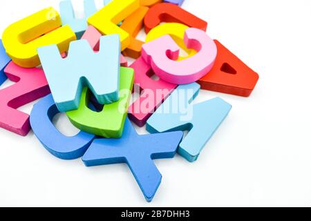 Bunte Buchstaben aus Holzalphabet isoliert auf weißem Hintergrund. Lernkonzept Stockfoto
