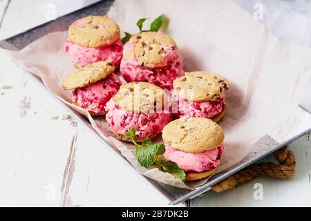 Himbeereissandwiches mit Schokolade-Chip-Plätzchen Stockfoto