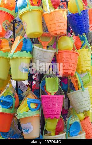 Plastikeimer und -Spaten im Netz an einem Stall an der Küste Stockfoto