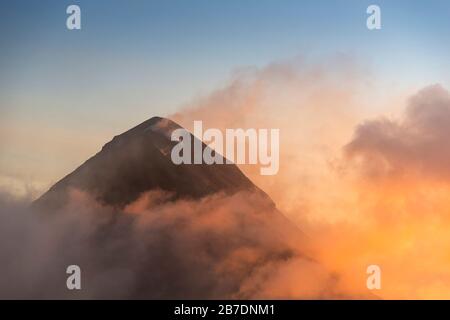 Vulkan Fuego (Volcan de Fuego) bei Sonnenuntergang mit Rauch und Wolken vom Vulkan Acatenango aus gesehen Stockfoto