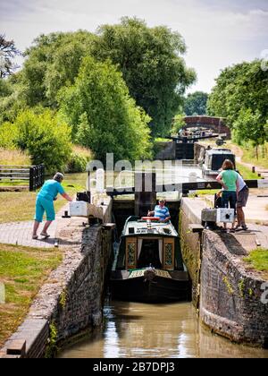 Schmalboot, das eine Schleuse auf dem Napton Flight of the Oxford Canal (South), Oxfordshire bei Napton on the Hill, England, Großbritannien, ausfährt Stockfoto