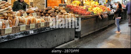 Ein computergroßes Banner zeigt Brot und frisches Obst, das auf dem überdachten Markt Mahane Yehudah in Jerusalem verkauft werden kann. Stockfoto