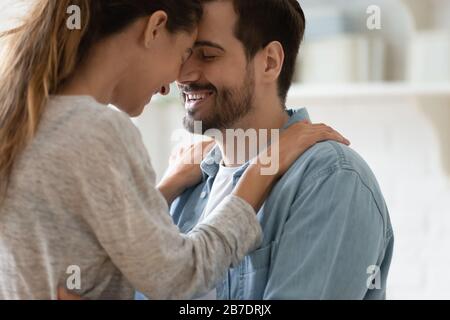 Schließen Sie glückliches Liebespaar, das die Stirn berührt, und genießen Sie einen zärtlichen Moment Stockfoto