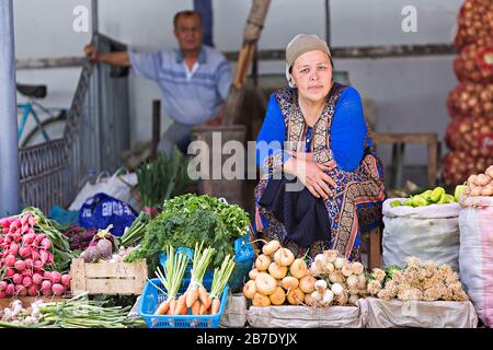 Usbekische Verkäuferin, die auf dem Markt Gemüse verkauft, in Margilan, Usbekistan. Stockfoto