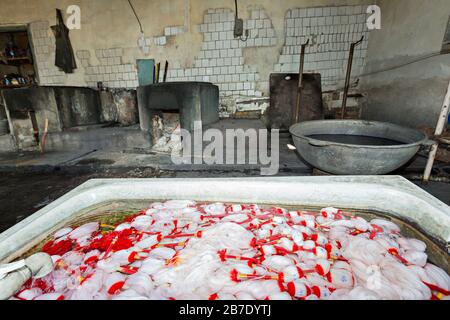 Seidenfabrik mit Seidenfäden in zu färbendem Wasser, in Margilan, Usbekistan Stockfoto