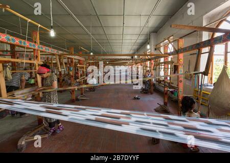 Frauen, die Seidenstoffe bearbeiten und wedeln, in der Seidenfabrik, Margilan, Usbekistan. Stockfoto