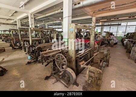 Alte Textilmaschinen zum Webeln von Seidenstoffen, in der Seidenfabrik, in Margilan, Usbekistan Stockfoto