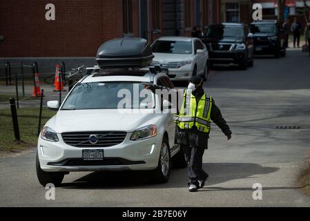 Massachusetts, USA. März 2020. Ein Wachmann, der das Fahrzeug während des vorzeitigen Auszugs aufgrund von Coronavirus (COVID-19) in der Nähe von Wohnhäusern im Harvard Yard lenkt. Studenten, die in Studentenwohnheimen leben, wurden gebeten, vor dem 22. März 2020 zu gehen. Nach Beschwerden von Studenten macht Harvard Unterkünfte für Studenten, die nicht in ihre Heimat zurückkehren können. Als Reaktion auf Coronavirus Bedenken gab die Harvard University bekannt, dass ab 23. März 2020 alle Klassen remote oder online sein werden. Credit: Chuck Nacke/Alamy Live News Stockfoto