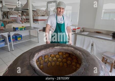 Usbekischer Hersteller backt lokales Gebäck, bekannt als Samsa, in Chorsu Bazaar, Taschkent, Usbekistan. Stockfoto