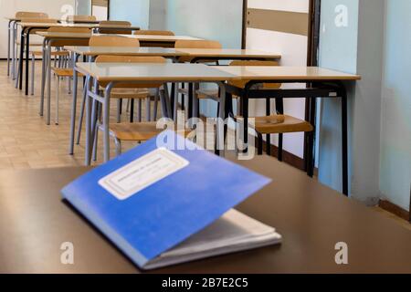 Das Klassenregister schloss auf dem Schreibtisch, in einer Klasse eines Gymnasiums, im Hintergrund die Schreibtische der Schüler. Übersetzung: "Klassenregister" Stockfoto