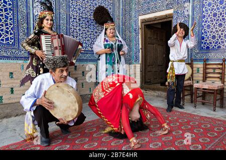 Khorezmian Musiker im lokalen Kleid, die lokale Musik und Tanz spielen, in Khiva, Usbekistan Stockfoto