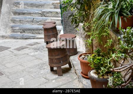 Holzhocker in Form eines Fasses in einer kleinen italienischen Straße in unmittelbarer Nähe Stockfoto