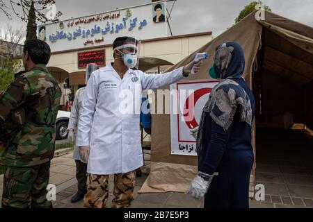 Der Arzt der iranischen Armee überwacht die Körpertemperatur von Menschen auf Straßen, die selbst eine Kontrolle fordern. Die landesweite militärische Zusammenkunft der iranischen Streitkräfte begann mit dem Ziel, das Coronavirus (COVID19) zu bekämpfen und die öffentliche Gesundheit auf Befehl des Obersten Anführers der Islamischen Republik Iran zu verbessern. Provinz Fars, Shiraz. März 2020. Stockfoto