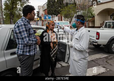 Der Arzt der iranischen Armee überwacht die Körpertemperatur von Menschen auf Straßen, die selbst eine Kontrolle fordern. Die landesweite militärische Zusammenkunft der iranischen Streitkräfte begann mit dem Ziel, das Coronavirus (COVID19) zu bekämpfen und die öffentliche Gesundheit auf Befehl des Obersten Anführers der Islamischen Republik Iran zu verbessern. Provinz Fars, Shiraz. März 2020. Stockfoto