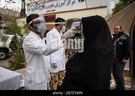 Der Arzt der iranischen Armee überwacht die Körpertemperatur von Menschen auf Straßen, die selbst eine Kontrolle fordern. Die landesweite militärische Zusammenkunft der iranischen Streitkräfte begann mit dem Ziel, das Coronavirus (COVID19) zu bekämpfen und die öffentliche Gesundheit auf Befehl des Obersten Anführers der Islamischen Republik Iran zu verbessern. Provinz Fars, Shiraz. März 2020. Stockfoto