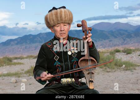 Musiker, der lokales traditionelles Instrument spielt, in Issyk Kul, Kirgisistan Stockfoto