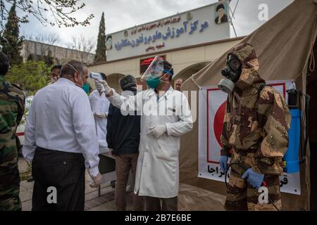 Der Arzt der iranischen Armee überwacht die Körpertemperatur von Menschen auf Straßen, die selbst eine Kontrolle fordern. Die landesweite militärische Zusammenkunft der iranischen Streitkräfte begann mit dem Ziel, das Coronavirus (COVID19) zu bekämpfen und die öffentliche Gesundheit auf Befehl des Obersten Anführers der Islamischen Republik Iran zu verbessern. Provinz Fars, Shiraz. März 2020. Stockfoto