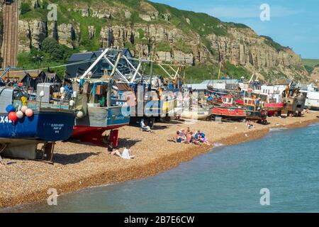 Hastings, Sonnenbaden am Fischbootstrand der Altstadt von Stade in Rock-a-Nore, East Sussex, Großbritannien Stockfoto