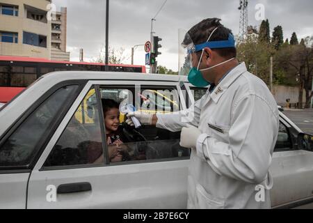 Der Arzt der iranischen Armee überwacht die Körpertemperatur von Menschen auf Straßen, die selbst eine Kontrolle fordern. Die landesweite militärische Zusammenkunft der iranischen Streitkräfte begann mit dem Ziel, das Coronavirus (COVID19) zu bekämpfen und die öffentliche Gesundheit auf Befehl des Obersten Anführers der Islamischen Republik Iran zu verbessern. Provinz Fars, Shiraz. März 2020. Stockfoto