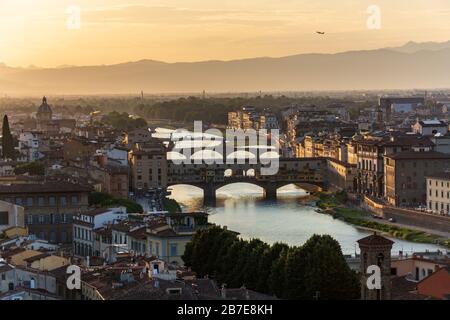 Die berühmte Brücke Ponte Vecchio in Florenz über den Fluss Arno bei Sonnenuntergang aus der Ferne Stockfoto