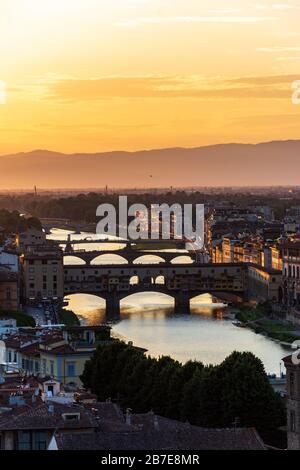 Die berühmte Brücke Ponte Vecchio in Florenz über den Fluss Arno bei Sonnenuntergang aus der Ferne Stockfoto