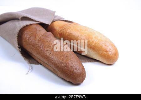 Zwei Baguettes in Leinwand gewickelt auf weißem Hintergrund. Horizontales Bild. Bild enthält Kopierbereich. Stockfoto