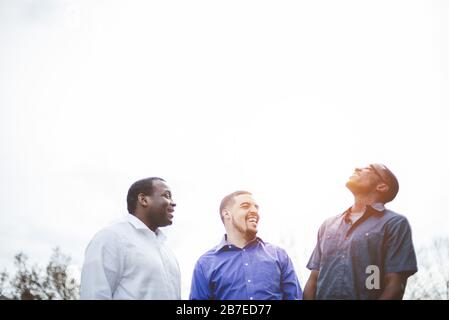 Low-Angle-Aufnahme einer Gruppe von glücklichen, vielfältigen Freunden Miteinander reden und lachen Stockfoto