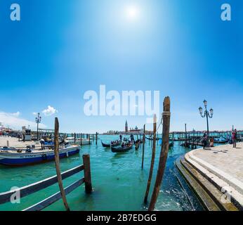 Venedig, Italien - 16. MAI 2019: Gondeln in der Nähe des Markusplatzes in Venedig mit der Kirche San Giorgio Maggiore im Hintergrund Stockfoto