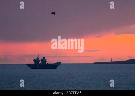 Lulworth, Dorset, Großbritannien. März 2020. Wetter in Großbritannien. Britains neuester Flugzeugträger "HMS Prince of Wales" ankerte bei Sonnenuntergang in der Weymouth Bay. Bildnachweis: Graham Hunt/Alamy Live News Stockfoto