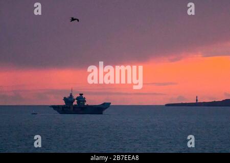 Lulworth, Dorset, Großbritannien. März 2020. Wetter in Großbritannien. Britains neuester Flugzeugträger "HMS Prince of Wales" ankerte bei Sonnenuntergang in der Weymouth Bay. Bildnachweis: Graham Hunt/Alamy Live News Stockfoto
