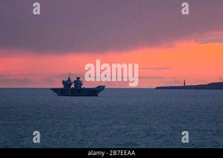 Lulworth, Dorset, Großbritannien. März 2020. Wetter in Großbritannien. Britains neuester Flugzeugträger "HMS Prince of Wales" ankerte bei Sonnenuntergang in der Weymouth Bay. Bildnachweis: Graham Hunt/Alamy Live News Stockfoto
