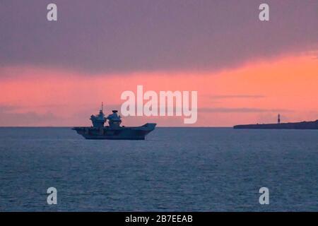 Lulworth, Dorset, Großbritannien. März 2020. Wetter in Großbritannien. Britains neuester Flugzeugträger "HMS Prince of Wales" ankerte bei Sonnenuntergang in der Weymouth Bay. Bildnachweis: Graham Hunt/Alamy Live News Stockfoto