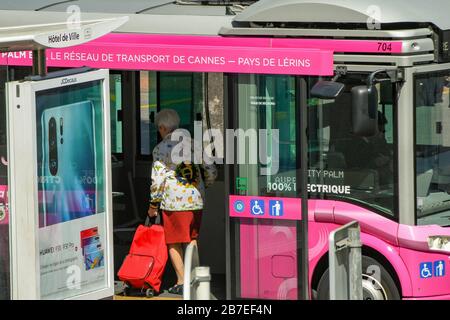 CANNES, FRANKREICH - APRIL 2019: Person mit Einkaufswagen in einem kleinen Elektrobus im Zentrum von Cannes. Stockfoto