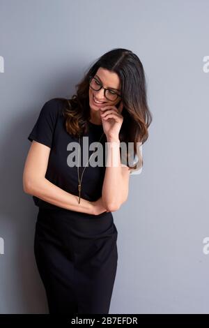Schöne Frau mit tollem Lächeln, die auf einem isolierten grauen Hintergrund mit Kopierraum steht. Stockfoto
