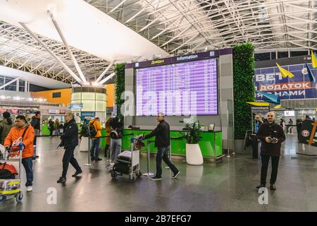 Passagiere auf einem internationalen Flughafen Borispol, Kiew, Ukraine 7. Februar 2020. Verspätung des Flugs, Personen Passagiere, die auf dem Flughafen warten und sich die Zeit anschauen Stockfoto