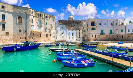 Türkisfarbenes Meer, Boote und weiße Häuser in der Altstadt von Monopoli, Apulien, Italien. Stockfoto