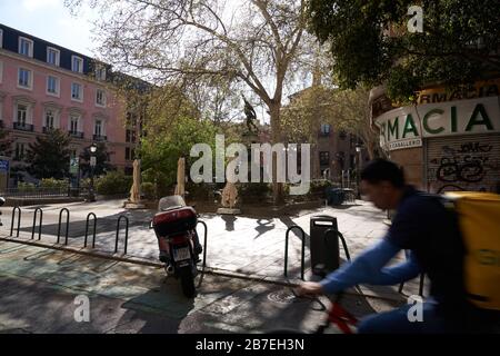 Ein Glovo-Heimlieferungsfahrer ist der einzige, der durch den leeren Königsplatz in Madrid infolge des Ausnahmezustands vorbeikommt Stockfoto