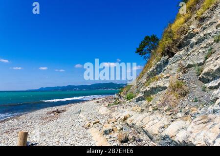 Rocky Meer mit Kieselstrand, transparente Wellen mit Schaum, an einem warmen Sommertag Stockfoto