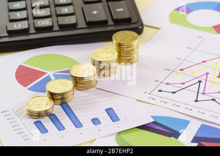 Stapel von Goldmünzen befinden sich auf farbigen Karten. Analyse des Geschäftszustands Stockfoto