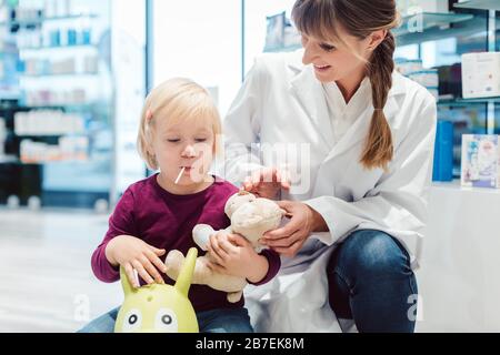 Kleines Mädchen in der Apotheke im Gespräch mit dem Apotheker Stockfoto