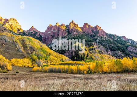 Maroon Bells Elch-Berge bei Sonnenaufgang Sonnenlicht in Aspen, Colorado mit felsigen Berggipfel im Oktober 2019 und lebhaften Bäumen Laub Herbst Stockfoto