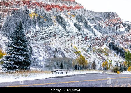 Maroon Bells Road und Picknicktisch in Aspen, Colorado felsiger Berg bedeckt im Schnee nach Winter gefroren im Herbst 2019 mit roten Bergen Stockfoto