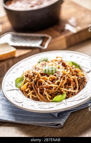 Italienische Pasta Spaghetti bolognese serviert auf weißem Teller mit Parmesankäse und Basilikum Stockfoto