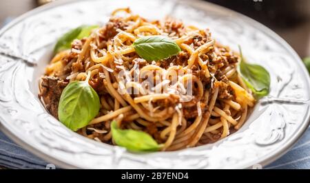 Italienische Pasta Spaghetti bolognese serviert auf weißem Teller mit Parmesankäse und Basilikum Stockfoto