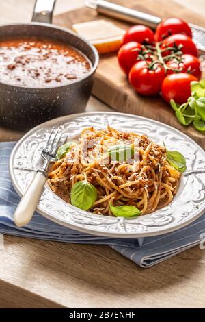 Italienische Pasta Spaghetti bolognese serviert auf weißem Teller mit Parmesankäse und Basilikum Stockfoto