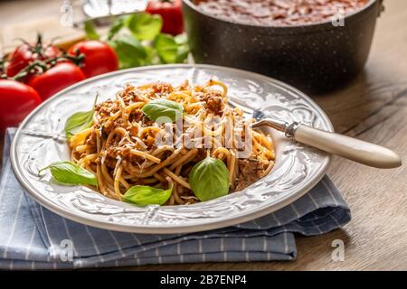 Italienische Pasta Spaghetti bolognese serviert auf weißem Teller mit Parmesankäse und Basilikum Stockfoto