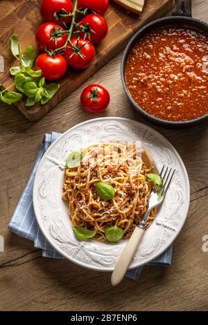 Italienische Pasta Spaghetti bolognese serviert auf weißem Teller mit Parmesankäse und Basilikum Stockfoto